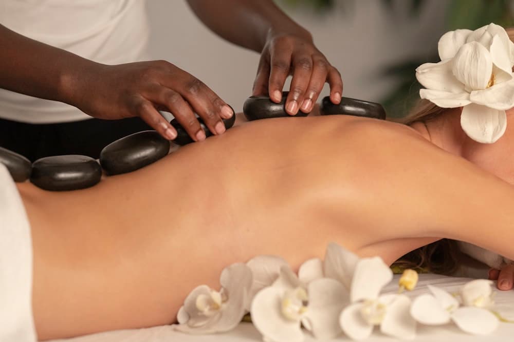 A warm mineral-stone massage in progress at Meraki